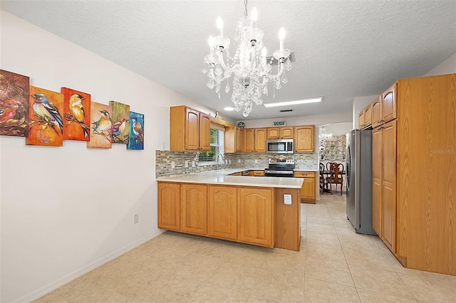 1002 Amarillo Pl, The Villages, FL 32159 - kitchen featuring stainless steel appliances, a chandelier, a peninsula, backsplash, and light countertops