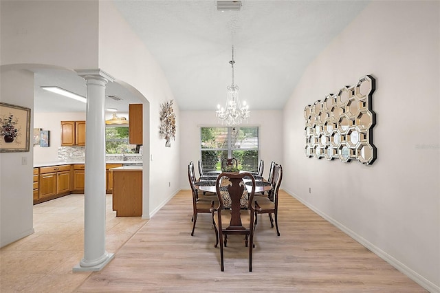 1002 Amarillo Pl, The Villages, FL 32159 - dining area featuring arched walkways, ornate columns, a chandelier, vaulted ceiling, and light wood-type flooring