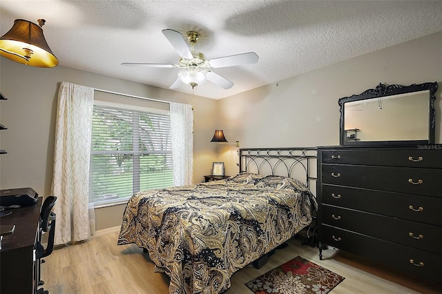 1002 Amarillo Pl, The Villages, FL 32159 - bedroom featuring light wood-style flooring, a textured ceiling, and a ceiling fan