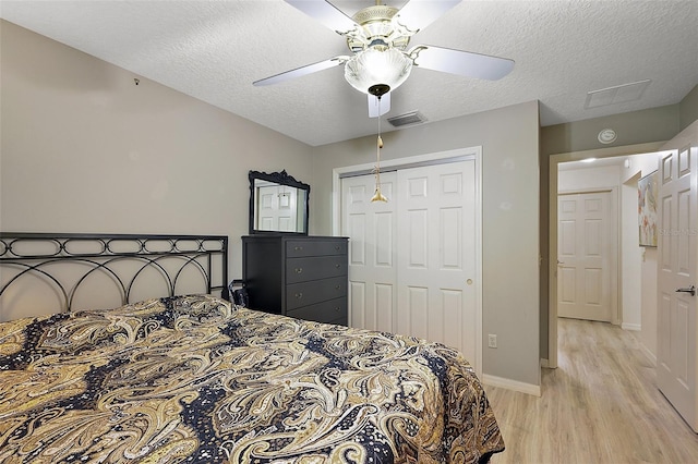 1002 Amarillo Pl, The Villages, FL 32159 - bedroom featuring light wood-style floors, a closet, a textured ceiling, and ceiling fan