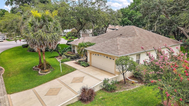 1002 Amarillo Pl, The Villages, FL 32159 - view of front of home featuring concrete driveway, a garage, a front yard, stucco siding, and a shingled roof