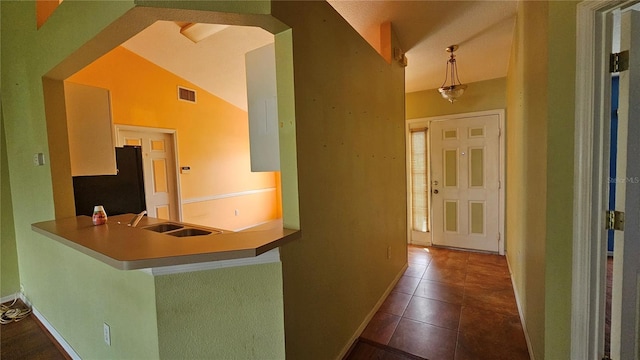 12512 Draw Dr, Grand Island, FL 32735 - kitchen with freestanding refrigerator, tile patterned floors, and a peninsula