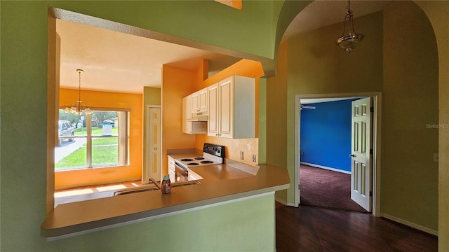 12512 Draw Dr, Grand Island, FL 32735 - kitchen with electric stove, dark wood-type flooring, under cabinet range hood, arched walkways, and decorative light fixtures