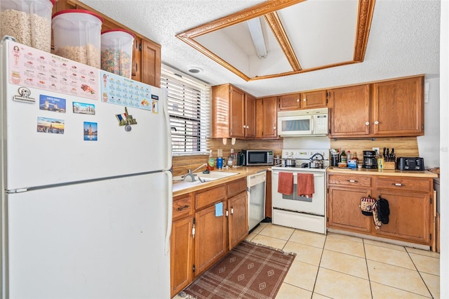 3401 Sunrise Villas Ct S, Tampa, FL 33614 - kitchen with stainless steel appliances, brown cabinetry, light tile patterned floors, light countertops, and a textured ceiling
