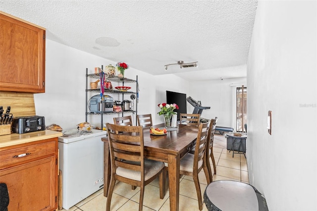 3401 Sunrise Villas Ct S, Tampa, FL 33614 - dining room featuring light tile patterned flooring, a textured ceiling, and washer / clothes dryer
