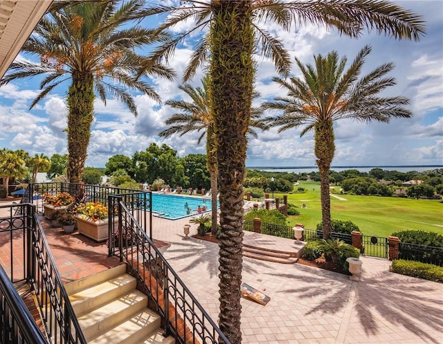 view of swimming pool featuring a patio and view of golf course