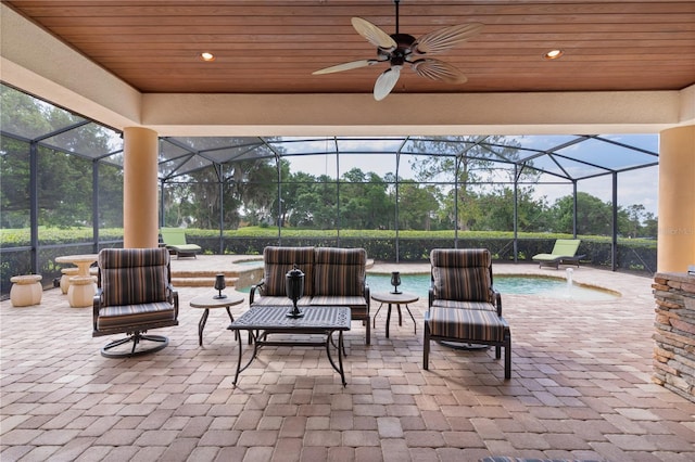 view of patio with a lanai, an outdoor pool, and a ceiling fan