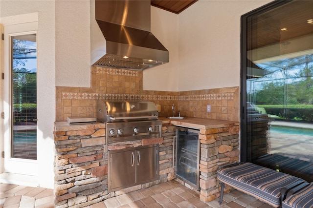 view of patio with beverage cooler, exterior kitchen, and an outdoor pool