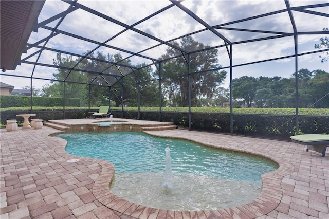 view of swimming pool featuring a patio area, a pool with connected hot tub, and a lanai