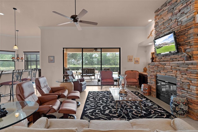 tiled living area featuring a stone fireplace, a ceiling fan, healthy amount of natural light, crown molding, and recessed lighting