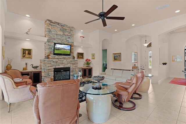 living room featuring arched walkways, ceiling fan, light tile patterned floors, a fireplace, and recessed lighting