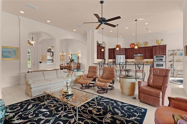 living area featuring arched walkways, light tile patterned floors, a ceiling fan, crown molding, and recessed lighting