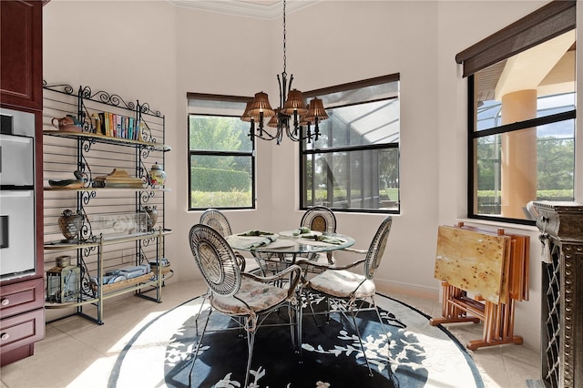 dining area with a chandelier, ornamental molding, and healthy amount of natural light