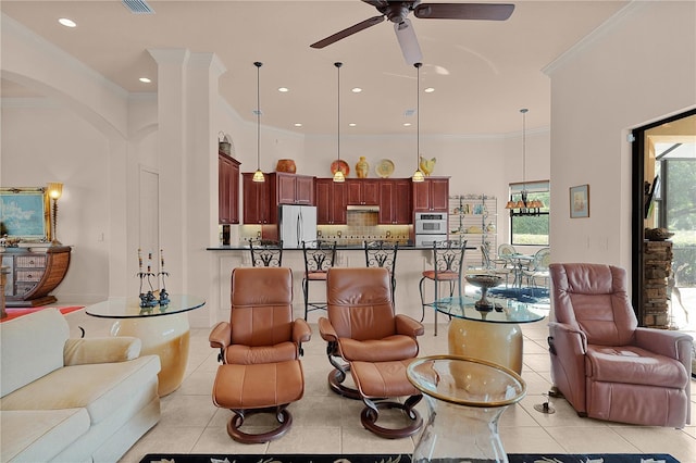 living area featuring light tile patterned floors, a ceiling fan, arched walkways, crown molding, and recessed lighting