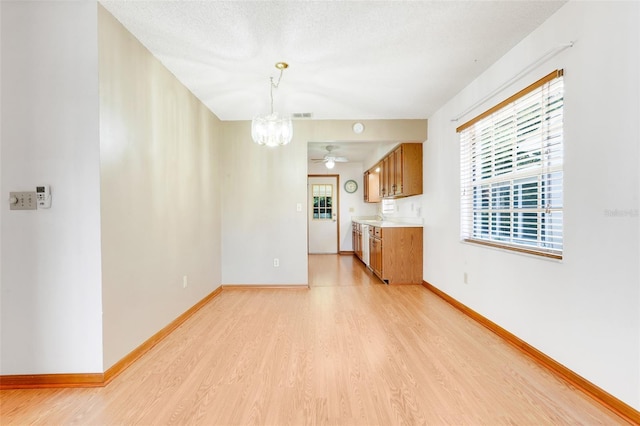 1467 Disston Ave, Clermont, FL 34711 - unfurnished living room with a chandelier, light wood finished floors, plenty of natural light, and ceiling fan