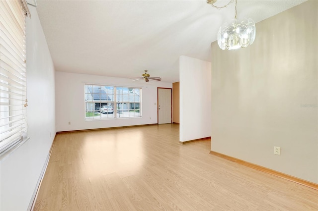 1467 Disston Ave, Clermont, FL 34711 - unfurnished living room featuring light wood-style floors, a chandelier, and ceiling fan