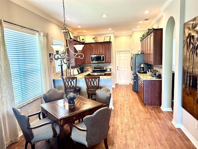 12183 SE 178th St, Summerfield, FL 34491 - dining space featuring arched walkways, healthy amount of natural light, light wood finished floors, crown molding, and recessed lighting