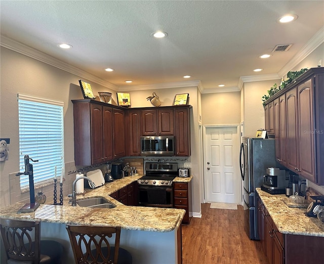 12183 SE 178th St, Summerfield, FL 34491 - kitchen with appliances with stainless steel finishes, a peninsula, a kitchen breakfast bar, decorative backsplash, and light stone counters