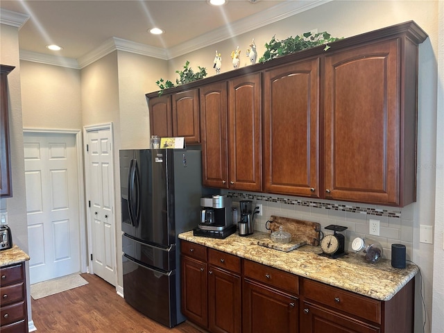 12183 SE 178th St, Summerfield, FL 34491 - kitchen featuring freestanding refrigerator, tasteful backsplash, ornamental molding, dark wood-style flooring, and light stone countertops