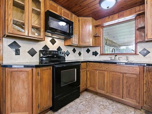 6731 Lake Griffin Rd, Lady Lake, FL 32159 - kitchen with black appliances, wood ceiling, brown cabinetry, decorative backsplash, and glass insert cabinets