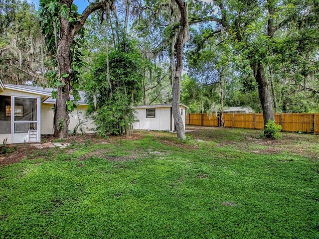 6731 Lake Griffin Rd, Lady Lake, FL 32159 - view of yard featuring a sunroom and view of wooded area