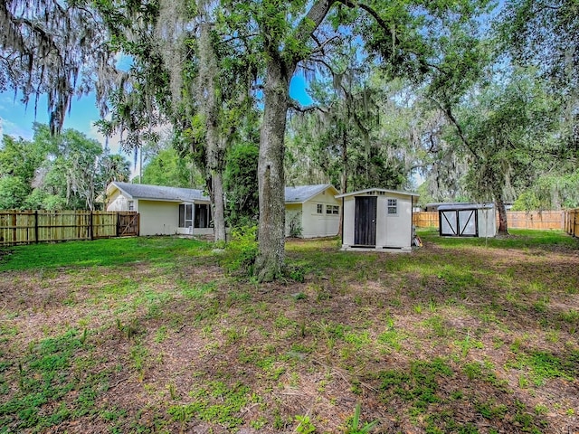 6731 Lake Griffin Rd, Lady Lake, FL 32159 - fenced backyard featuring a shed and view of wooded area
