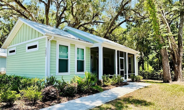 3607 Umbrella Tree Ln, Oxford, FL 34484 - view of home's exterior featuring a sunroom, board and batten siding, and a metal roof