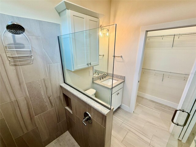 3607 Umbrella Tree Ln, Oxford, FL 34484 - bathroom featuring tiled shower, vanity, and a walk in closet