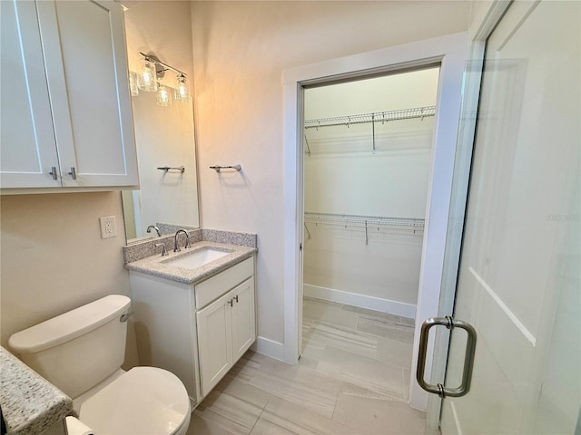 3607 Umbrella Tree Ln, Oxford, FL 34484 - bathroom with vanity, a spacious closet, and marble look tiles