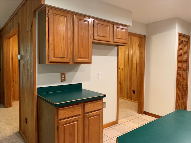 2530 Shady Ln, Groveland, FL 34736 - kitchen featuring brown cabinets, dark countertops, light tile patterned floors, and light carpet