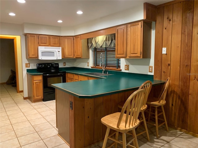2530 Shady Ln, Groveland, FL 34736 - kitchen with white microwave, black range with electric stovetop, light tile patterned floors, a peninsula, and a kitchen breakfast bar