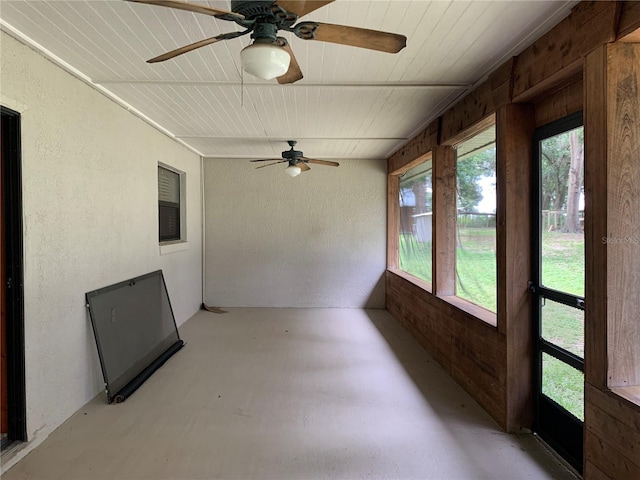 2530 Shady Ln, Groveland, FL 34736 - unfurnished sunroom with finished concrete floors, a textured wall, wooden ceiling, and wooden walls