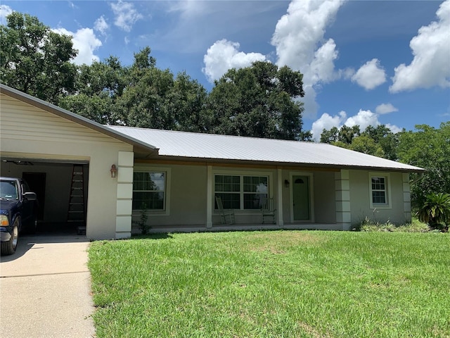 2530 Shady Ln, Groveland, FL 34736 - ranch-style house with driveway, a metal roof, a front yard, stucco siding, and a garage