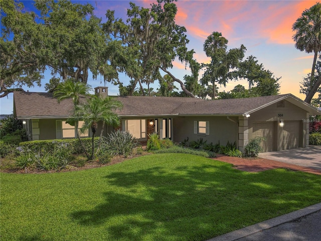 504 Banning Beach Rd, Tavares, FL 32778 - ranch-style home with an attached garage, a lawn, concrete driveway, and stucco siding