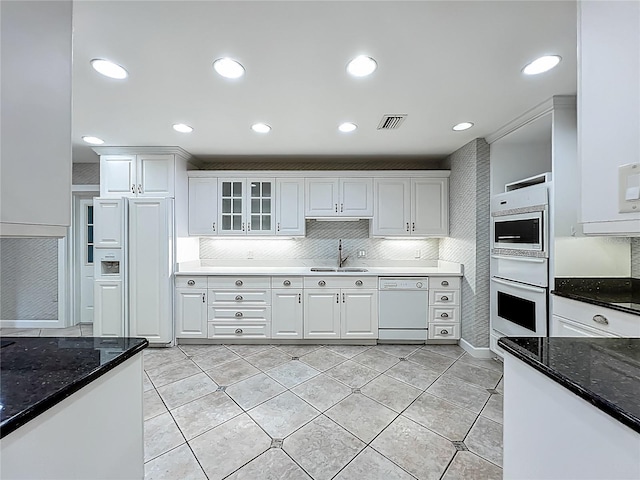 504 Banning Beach Rd, Tavares, FL 32778 - kitchen featuring white appliances, white cabinets, dark stone countertops, glass insert cabinets, and recessed lighting