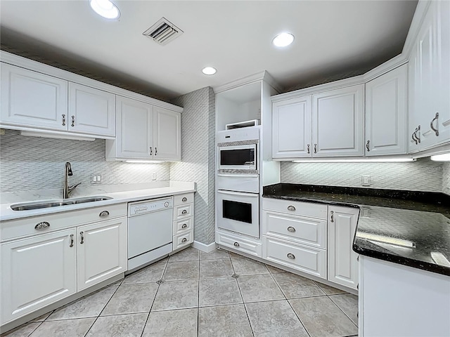 504 Banning Beach Rd, Tavares, FL 32778 - kitchen featuring white appliances, white cabinets, light tile patterned floors, decorative backsplash, and recessed lighting