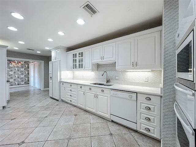 504 Banning Beach Rd, Tavares, FL 32778 - kitchen with white dishwasher, stainless steel oven, light countertops, white cabinetry, and recessed lighting