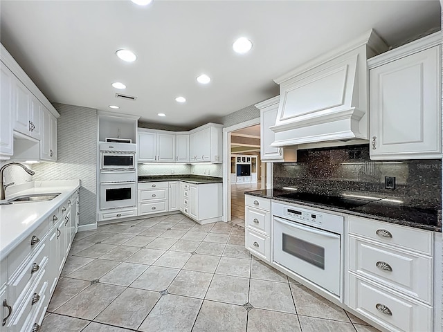 504 Banning Beach Rd, Tavares, FL 32778 - kitchen featuring black electric cooktop, white cabinetry, tasteful backsplash, light tile patterned floors, and recessed lighting