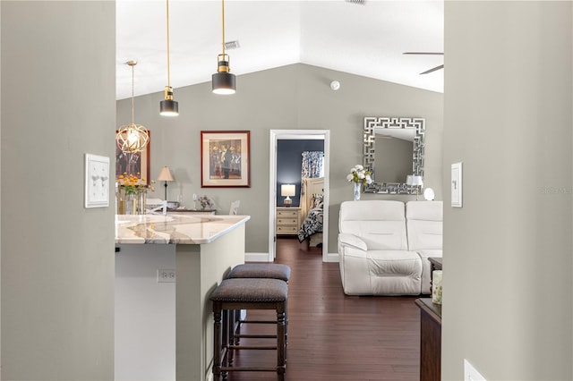 9790 SE 175th St, Summerfield, FL 34491 - kitchen featuring vaulted ceiling, a kitchen breakfast bar, dark wood-style flooring, ceiling fan, and light stone counters