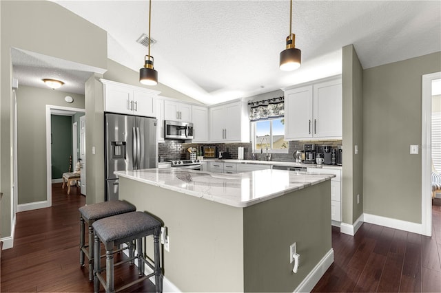 9790 SE 175th St, Summerfield, FL 34491 - kitchen with stainless steel appliances, a kitchen island, tasteful backsplash, dark wood-style floors, and a textured ceiling