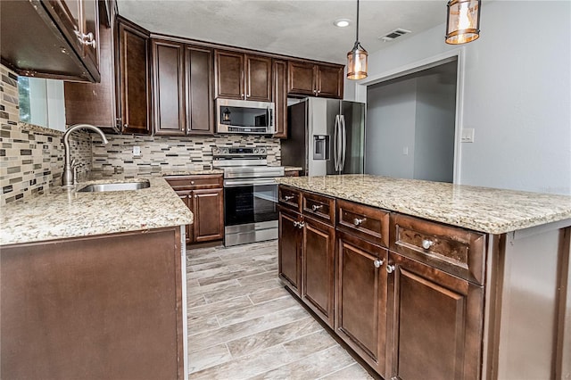 25 Jule Rd, Macclenny, FL 32063 - kitchen featuring stainless steel appliances, backsplash, dark brown cabinetry, hanging light fixtures, and light stone counters