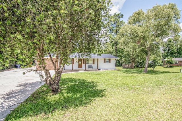 25 Jule Rd, Macclenny, FL 32063 - ranch-style home with a porch, concrete driveway, a front lawn, and a metal roof