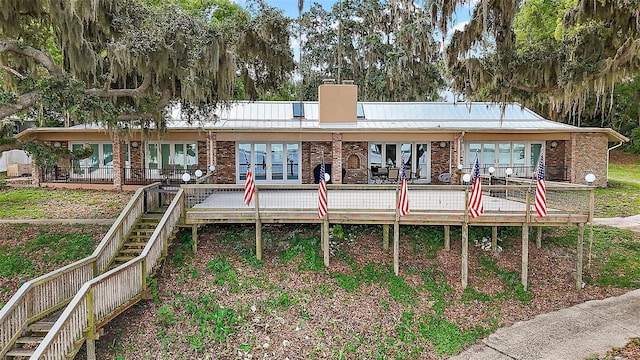 13033 SE 158th Ln, Weirsdale, FL 32195 - rear view of property featuring brick siding, a chimney, a deck, and stairs