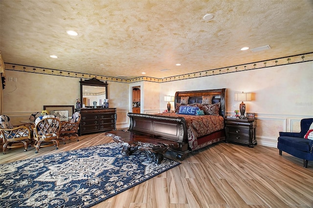 13033 SE 158th Ln, Weirsdale, FL 32195 - bedroom featuring wood finished floors, a decorative wall, wainscoting, and recessed lighting