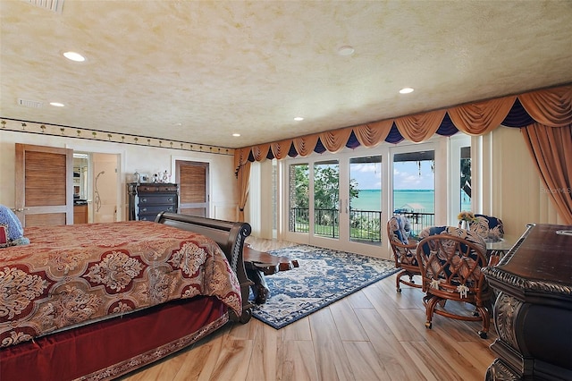 13033 SE 158th Ln, Weirsdale, FL 32195 - bedroom with wood finished floors, recessed lighting, a water view, and access to exterior