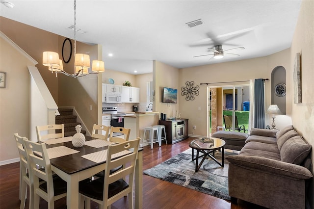 624 Terra Lago St, Davenport, FL 33897 - dining space with dark wood-type flooring, ceiling fan, stairway, a chandelier, and arched walkways