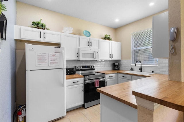 624 Terra Lago St, Davenport, FL 33897 - kitchen featuring white appliances, wooden counters, white cabinetry, decorative backsplash, and a peninsula