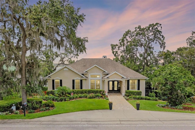 6136 Lake Emma Rd, Groveland, FL 34736 - view of front of home featuring french doors, a front lawn, and stucco siding
