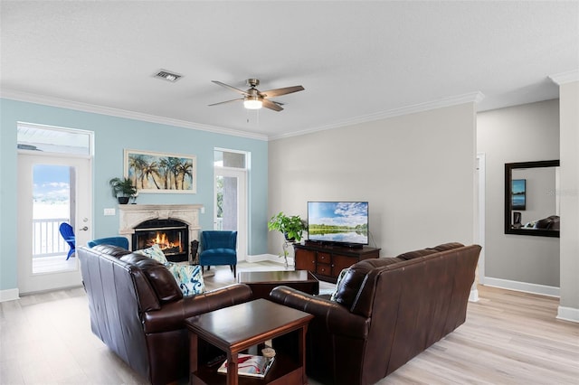 6136 Lake Emma Rd, Groveland, FL 34736 - living area with light wood-style flooring, a warm lit fireplace, crown molding, ceiling fan, and plenty of natural light