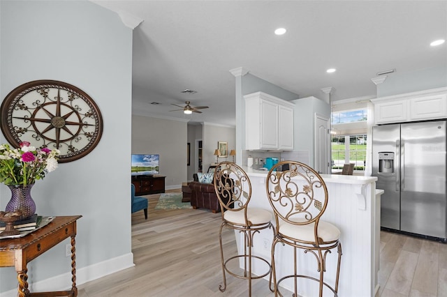 6136 Lake Emma Rd, Groveland, FL 34736 - kitchen with stainless steel fridge with ice dispenser, a peninsula, light wood-style flooring, a kitchen breakfast bar, and a ceiling fan